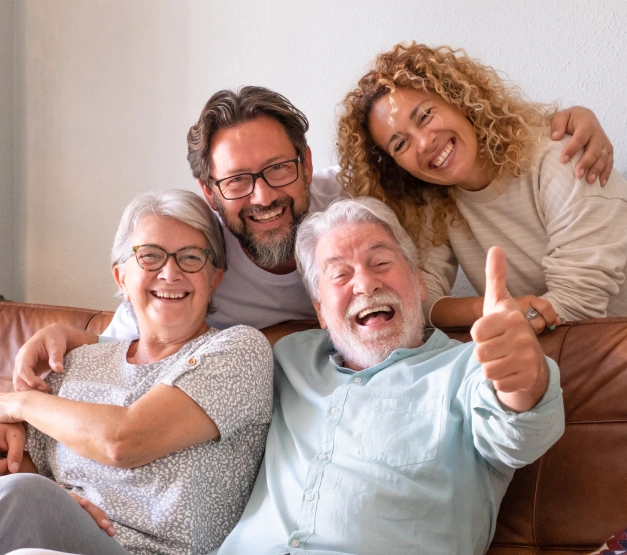 Happy multi-generational family smiling and posing together indoors at dental office.